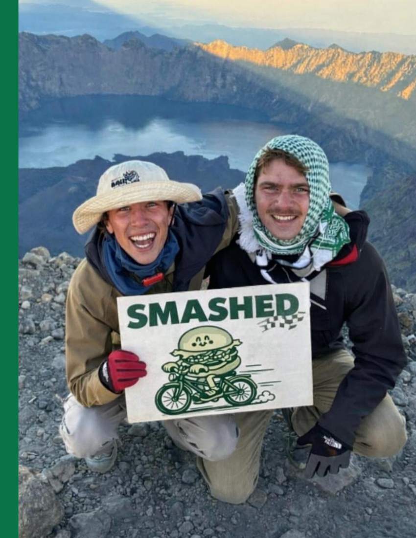 Maxime et Pierre au sommet du mont Rinjani avec un panneau SMASHED